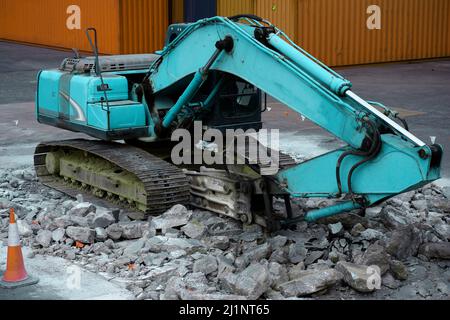 Escavatore da roccia in funzione per demolire il calcestruzzo. Foto Stock