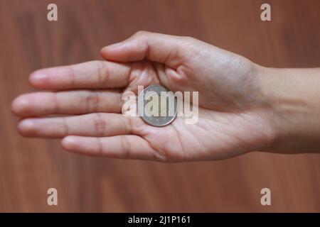 La moneta canadese sulla mano della donna, la moneta nella mano delle donne Foto Stock