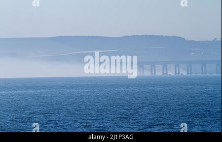 Dundee, Tayside, Scozia, Regno Unito. 27th marzo 2022. Tempo britannico: A causa dell'aria fredda proveniente dall'ovest, si forma una bassa nebbia densa attraverso il fiume Tay, creando viste mozzafiato su Dundee. Le temperature scesero a 14°C. Più tardi nel giorno, il sole disperde la nebbia, permettendo al sole caldo di brillare e le temperature nella Scozia nord-orientale per raggiungere i 18°C. Viste spettacolari dal lungofiume di Dundee del Ponte di Tay Road, il Fiume Tay, il Ponte della Ferrovia di Tay e il Museo del Design V&A in primavera. Credit: Dundee Photographics/Alamy Live News Foto Stock