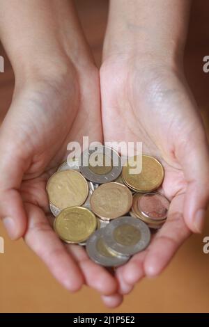 La moneta canadese sulla mano della donna, la moneta nella mano delle donne Foto Stock