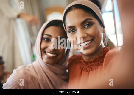 Non c'è amore più grande che amore fratello. Shot di due sorelle musulmane che prendono insieme selfie. Foto Stock
