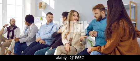 Gruppo multietnico di giovani che discutono qualcosa durante la riunione d'affari in carica Foto Stock