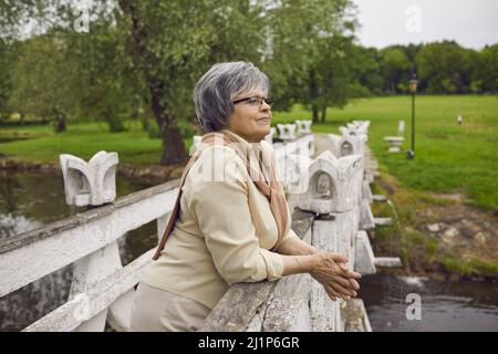 Nonna matura dai capelli grigi rilassarsi sogno nel parco Foto Stock