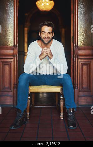 Il segreto a guardare bene è sentirsi bene. Ritratto di un bell'uomo vestito casual in posa su una sedia. Foto Stock