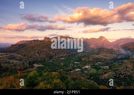 Vista aerea della catena montuosa con cielo colorato nella foresta pluviale tropicale in campagna di sera Foto Stock