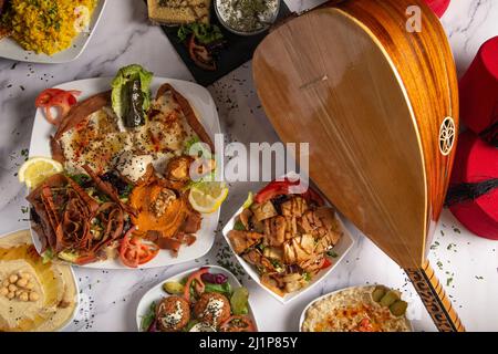 Vista dall'alto di una varietà di piatti della cucina mediorientale e araba su sfondo bianco. Foto Stock