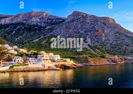 Splendida vista dell'isola mediterranea al tramonto. Piccolo villaggio di pescatori greco in raggi di sole basso. Sun flares, case imbiancate, Milos, Grecia. Foto Stock