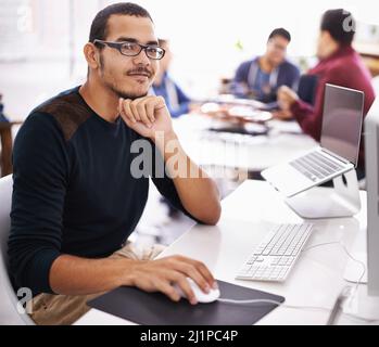 Sicuro del suo ruolo nel team. Scatto ritagliato di un giovane che lavora sul suo portatile in ufficio. Foto Stock