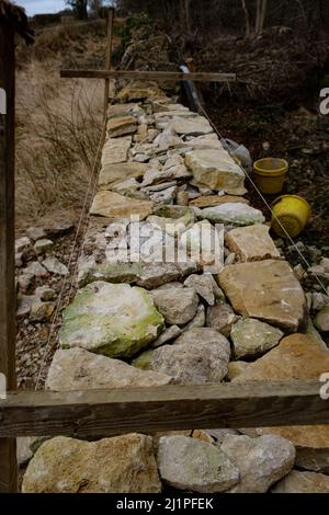 Costruzione di un muro di pietra a secco - pareti di pietra a secco nei Cotswolds Foto Stock