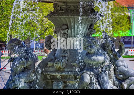 Fontana con putti in Schlossplatz di fronte al Palazzo nuovo (Neues Schloss) a Stoccarda, Baden-Württemberg, Germania. Foto Stock