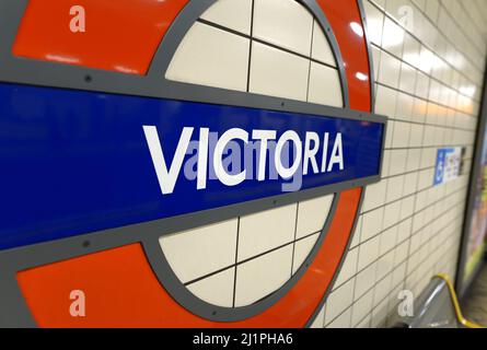 Londra, Inghilterra, Regno Unito. Piattaforma della stazione della metropolitana di Victoria - roundel Foto Stock