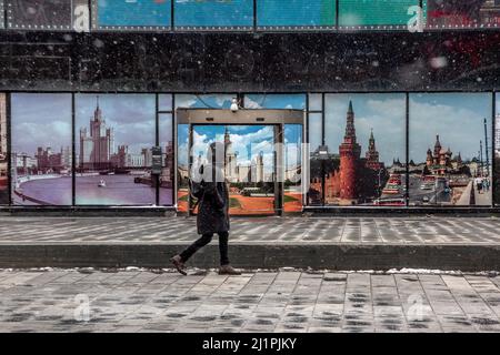 Mosca, Russia. 27th marzo 2022 Un uomo cammina lungo la strada sullo sfondo dell'ingresso al nightclub Metelitsa in Novy Arbat Street a Mosca durante il tempo ventoso e la nevicata, Russia Foto Stock