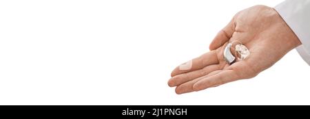 Apparecchio acustico in mano del medico, che viene dato a pazienti non udenti per trattamenti uditivi. Soluzioni acustiche, apparecchi acustici BTE Foto Stock
