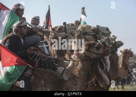 Wadi al Salqa, territori palestinesi. 27th Mar 2022. I beduini palestinesi cavalcano cavalli e cammelli mentre prendono parte a una corsa tradizionale per celebrare la Giornata della Terra. Land Day segna un incidente avvenuto nel 1976, quando le truppe israeliane hanno sparato e ucciso sei persone durante le proteste contro le confische terrestri. Credit: Mohammed Talatene/dpa/Alamy Live News Foto Stock