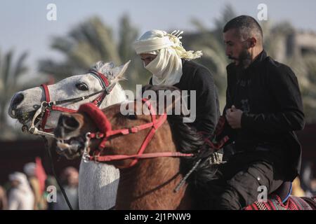 Wadi al Salqa, territori palestinesi. 27th Mar 2022. I beduini palestinesi cavalcano cavalli e cammelli mentre prendono parte a una corsa tradizionale per celebrare la Giornata della Terra. Land Day segna un incidente avvenuto nel 1976, quando le truppe israeliane hanno sparato e ucciso sei persone durante le proteste contro le confische terrestri. Credit: Mohammed Talatene/dpa/Alamy Live News Foto Stock