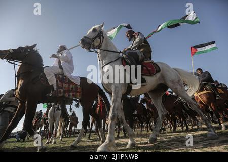 Wadi al Salqa, territori palestinesi. 27th Mar 2022. I beduini palestinesi cavalcano cavalli e cammelli mentre prendono parte a una corsa tradizionale per celebrare la Giornata della Terra. Land Day segna un incidente avvenuto nel 1976, quando le truppe israeliane hanno sparato e ucciso sei persone durante le proteste contro le confische terrestri. Credit: Mohammed Talatene/dpa/Alamy Live News Foto Stock