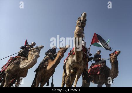 Wadi al Salqa, territori palestinesi. 27th Mar 2022. I beduini palestinesi cavalcano cavalli e cammelli mentre prendono parte a una corsa tradizionale per celebrare la Giornata della Terra. Land Day segna un incidente avvenuto nel 1976, quando le truppe israeliane hanno sparato e ucciso sei persone durante le proteste contro le confische terrestri. Credit: Mohammed Talatene/dpa/Alamy Live News Foto Stock