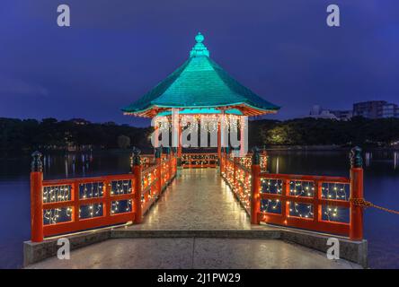 fukuoka, kyushu - dicembre 06 2021: Vista notturna della passerella illuminata adornata da luccicanti ghirlande che conducono al Padiglione Ukimi-do all'esterno Foto Stock