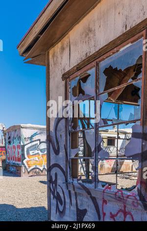 Una casa vandalizzata con vetri rotti della finestra e graffiti dipinti a spruzzo nell'insediamento di Bombay Beach, California. Foto Stock