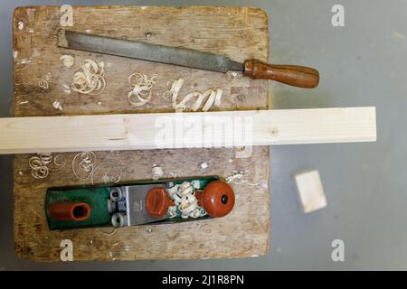 piallatrice, lima e blocco di legno su uno sgabello Foto Stock