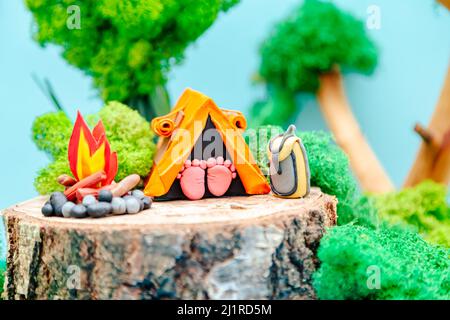 Campo turistico. Paesaggio plastificato con una tenda, un falò e uno zaino in mezzo alla foresta. Il concetto di eco-friendly ricreazione e envi Foto Stock