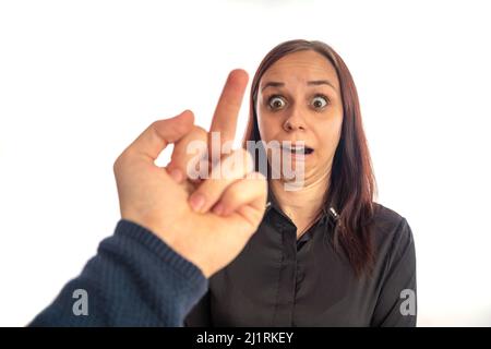 La mano dell'uomo mostra il dito medio alla giovane donna Foto Stock