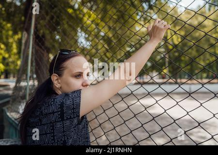 Le mani sul reticolo simboleggiano la limitazione in qualcosa. Foto Stock
