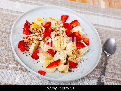 Gelato con banane e fragole servito sul piatto Foto Stock