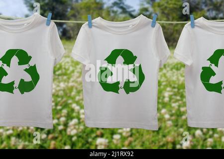 Icona del riciclaggio dei vestiti sulle t-shirt on line, riutilizzo sostenibile del concetto di moda, riciclaggio dei vestiti e tessuti per ridurre gli sprechi Foto Stock