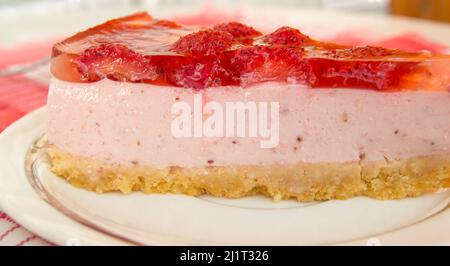 Cheesecake alla fragola fresca, un pezzo con strati, vista laterale, primo piano. Foto Stock