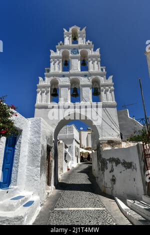 Una tipica strada acciottolata con un campanile ad arco nel tradizionale villaggio di Megalochori a Santorini, in Grecia. Foto Stock