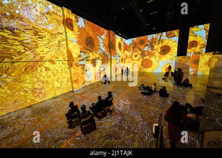 Toronto, Canada. 26th Mar 2022. La gente ha visto stare seduti mentre si guarda una coinvolgente mostra d'arte che mostra il lavoro di Van Gogh sui fiati di fieno e sui campi di grano. L'immersiva mostra Van Gogh è dedicata alle opere d'arte del pittore Vincent Van Gogh a Toronto, Canada. Trasformando uno spazio di magazzino di 5 piani di 600.000 piedi cubi in una galleria digitale illuminata, oltre 18 mostre simili possono essere attualmente trovate in tutto il Nord America. Credit: SOPA Images Limited/Alamy Live News Foto Stock