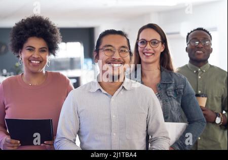 Il lavoro di squadra consente a un'azienda di progredire. Ritratto di un gruppo di giovani imprenditori fiduciosi che lavorano in un ufficio moderno. Foto Stock