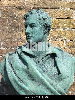 Vecchia statua di bronzo di Lord Byron in un giardino murato Foto Stock