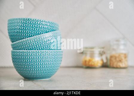 Tre ciotole vuote blu sul tavolo da cucina con spazio copia, vista frontale, interno cucina Foto Stock