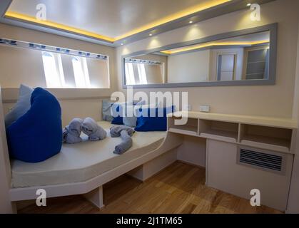 Decorazioni interne della camera da letto in cabina su yacht di lusso con letto matrimoniale Foto Stock