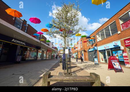 Ombrelloni colorati sospesi a mezz'aria in un centro città Foto Stock