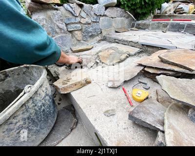 Un uomo stende una pietra sui sentieri del mortaio Foto Stock