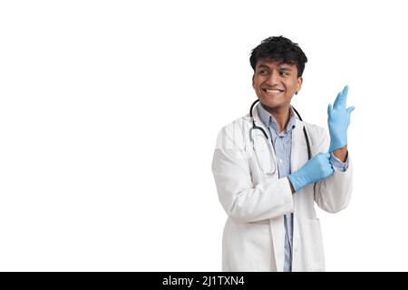 Giovane medico peruviano maschio sorridente e indossare guanti blu, isolato. Foto Stock