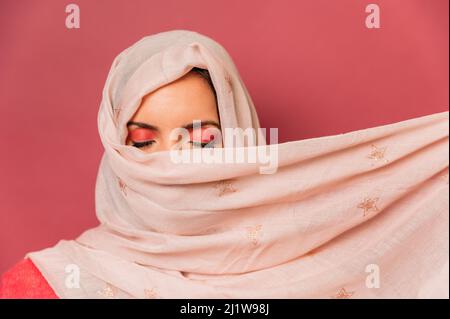 Vista laterale del corpo del passeggero seduto con bagagli in aeroporto e con il cellulare contro la vista panoramica attraverso la finestra Foto Stock