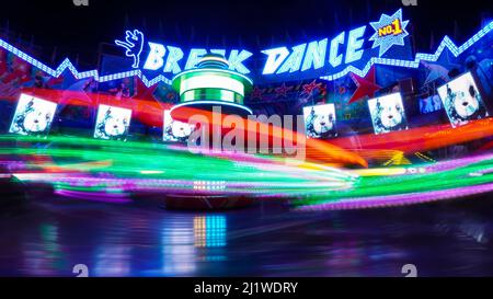 Breakdance sul funfair di notte in movimento sfocatura - esposizione di lunga durata Foto Stock