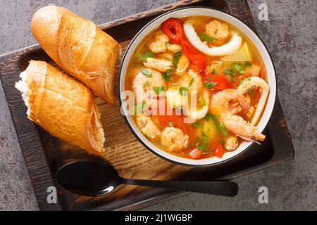 Stufato di pesce fresco con patate, peperoni, pomodori e cipolle da vicino in una ciotola sul tavolo. Vista dall'alto orizzontale dall'alto Foto Stock