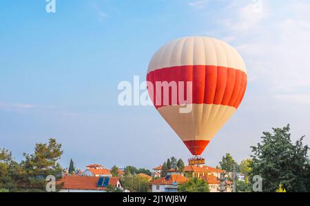 mongolfiera vola a bassa velocità sulle città Foto Stock