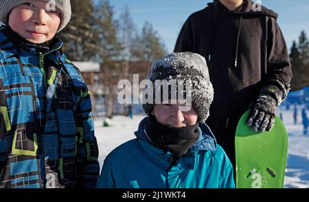 Umea, Norrland Svezia - 19 febbraio 2022: Tre bambini in abiti da sci in posa sulle piste Foto Stock