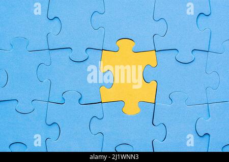 Il pezzo di puzzle giallo si distingue dalla folla. Diversità, concetto unico o differenza. Foto Stock