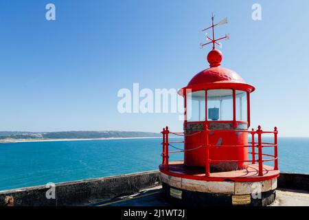 Faro rosso sul forte di Sao Miguel a Nazaré, Portogallo, un osservatorio privilegiato per la stagione delle onde Foto Stock