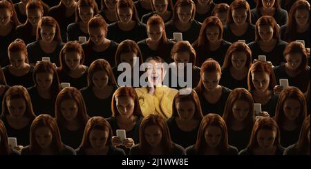 Vista dall'alto della folla grigia di persone identiche con gadget, dipendenza dalla rete e una ragazza speciale eccitato. Concetto di differenza e diversità Foto Stock