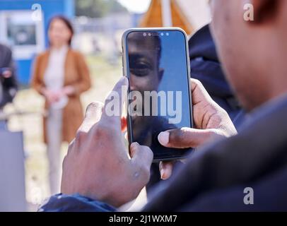 28 marzo 2022, Brandeburgo, Eisenhüttenstadt: Un rifugiato di Kiev vuole fotografare il Ministro federale degli esteri Baerbock con il suo cellulare. Oggi Baerbock sta visitando la struttura centrale di accoglienza iniziale per i richiedenti asilo a Eisenhüttenstadt. Foto: Annette Riedl/dpa Foto Stock