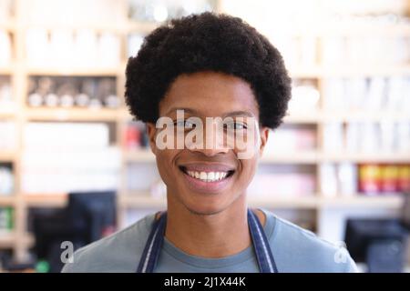 Primo piano ritratto di felice giovane uomo africano americano proprietario con acconciatura afro. Inalterato, caffè cultura, persone e concetto di occupazione. Foto Stock