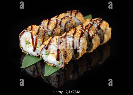 Rotolo caldo di tempura impostato su uno sfondo nero con riflessi. Sushi roll con riso, nori, formaggio spalmabile, pesce anguilla, avocado. Menu di sushi. Cucina giapponese, Foto Stock